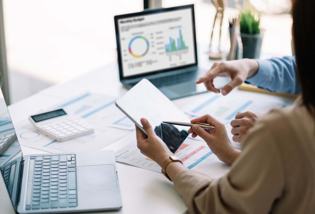 Two people reviewing graphs and charts for Ascend Business Brokers financial planning