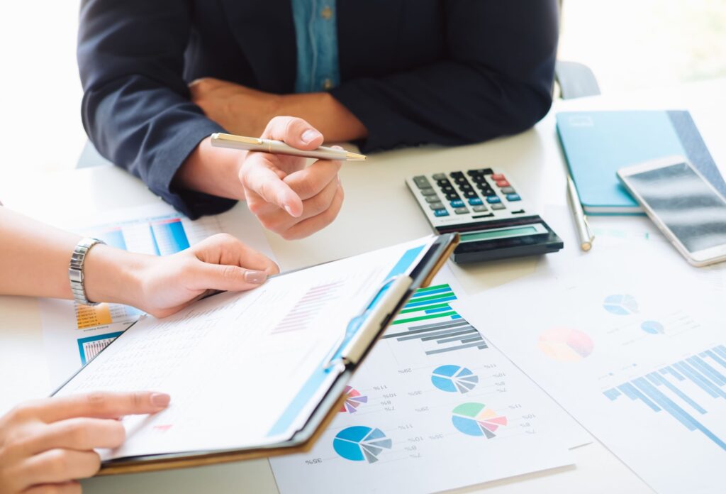 Two people reviewing graphs and charts for Ascend Business Brokers financial planning