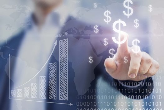 Hands typing business data into laptop with graphs for Ascend Business Brokers report generation tools.